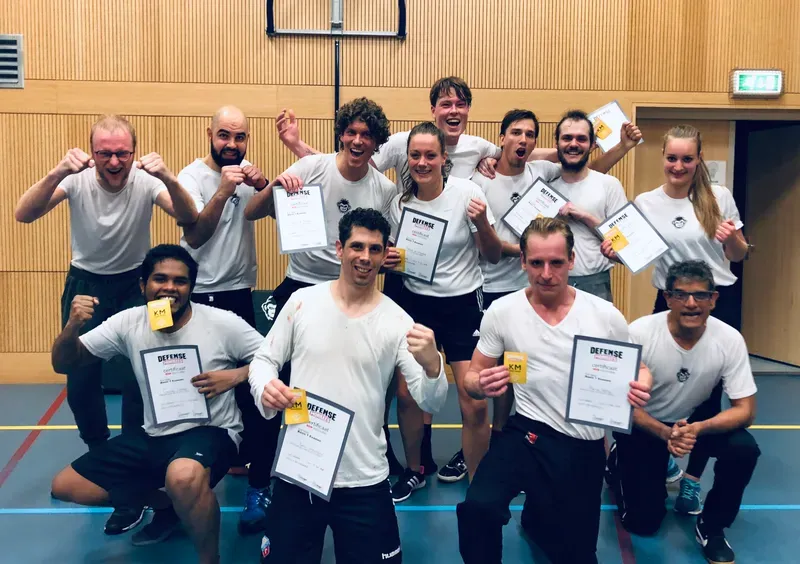 Group of DefenseMonkees members with their Krav Maga certificates and patches after an exam